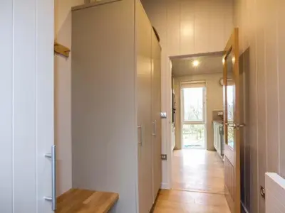 a hallway of a house with a door to a kitchen at Shepherd Lodge in Cartmel