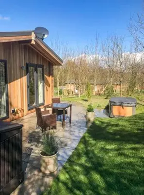a backyard with a picnic table and a house at Shepherd Lodge in Cartmel