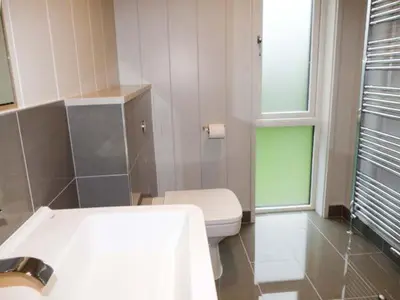 a bathroom with a toilet and a sink and a window at Crook Lodge in Cartmel