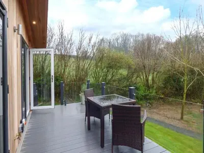 a patio with a table and chairs on a porch at Crook Lodge in Cartmel