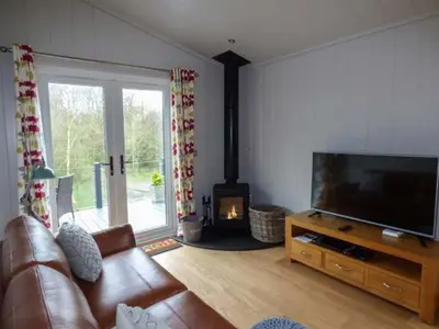 a living room with a couch and a flat screen tv at Crook Lodge in Cartmel