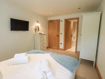a bedroom with a bed with towels on it at Yew Cottage in Backbarrow