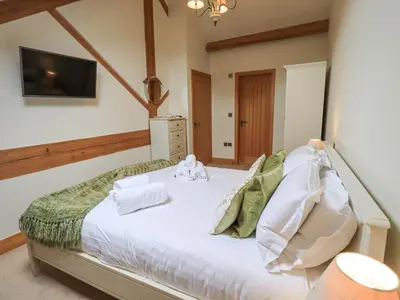 a bedroom with a bed with towels on it at Yew Cottage in Backbarrow