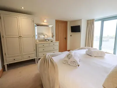 a bedroom with a white bed with towels on it at Lime Cottage in Backbarrow