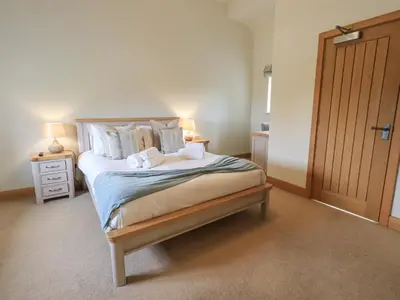 a bedroom with a large bed with two pillows at Lime Cottage in Backbarrow