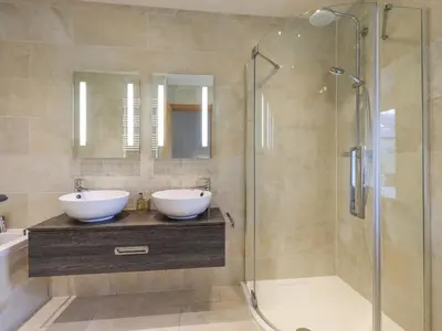 a bathroom with two sinks and a shower at Lime Cottage in Backbarrow