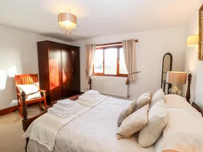 a bedroom with a large bed with pillows on it at Green Hills Farm in Greenodd