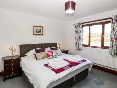 a bedroom with a bed with two towels on it at Green Hills Farm in Greenodd