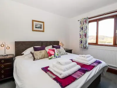 a bedroom with a bed with two towels on it at Green Hills Farm in Greenodd