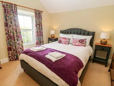 a bedroom with a large bed with two towels on it at Waingate Cottage in Cark
