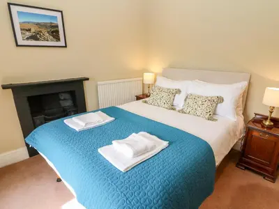 a bedroom with a bed with two towels on it at Waingate Cottage in Cark