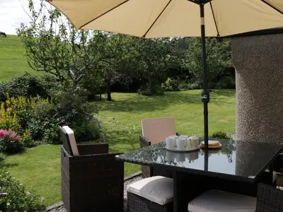 a table and chairs with an umbrella and a table and chairs sidx sidx sidx at Waingate Cottage in Cark