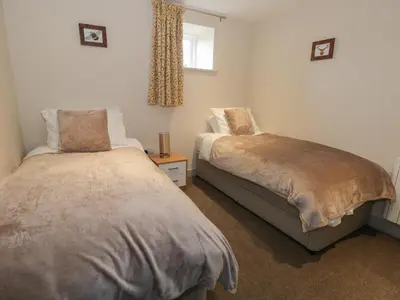 a bedroom with two beds and a window at The Granary Loft in Sunbrick