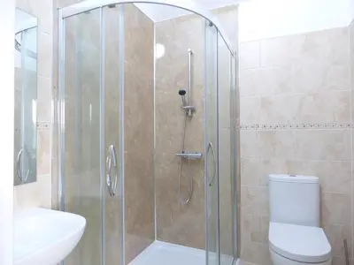 a bathroom with a shower with a toilet and a sink at Cow Hill Laith Barn in Sawley