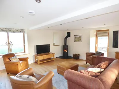 a living room with couches and a fire place at Cow Hill Laith Barn in Sawley