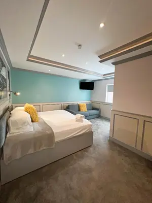 a bedroom with a bed and a couch in it at Central Station Hotel Liverpool in Liverpool