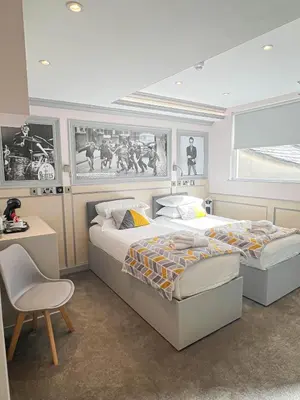 a bedroom with two beds and a table and a chair at Central Station Hotel Liverpool in Liverpool