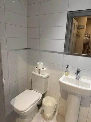 a white bathroom with a toilet and a sink at Central Station Hotel Liverpool in Liverpool