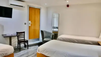 a hotel room with two beds and a desk and a chair at Print Works Hotel in Liverpool