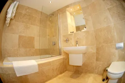 a bathroom with a sink and a tub and a toilet at Print Works Hotel in Liverpool