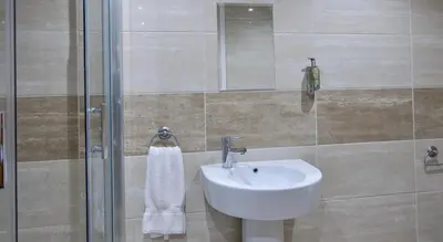 a bathroom with a sink and a shower at Print Works Hotel in Liverpool