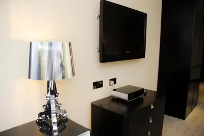 a room with a table with a lamp and a tv at Print Works Hotel in Liverpool