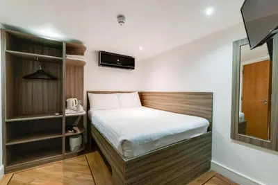 a small bedroom with a bed and a mirror at Print Works Hotel in Liverpool
