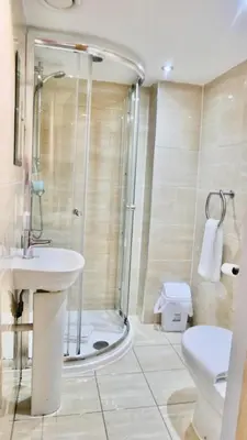 a bathroom with a shower and a sink and a toilet at Print Works Hotel in Liverpool