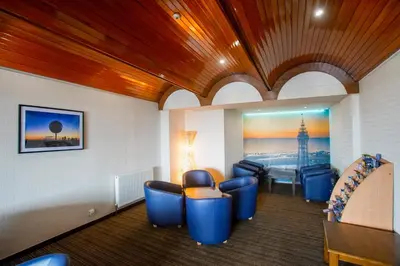 a waiting room with blue chairs and a table at Craig-y-Don in Blackpool