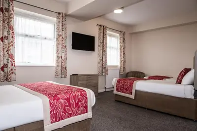 a hotel room with two beds and a flat screen tv at Craig-y-Don in Blackpool