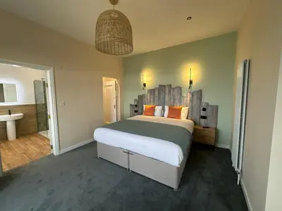 a bedroom with a large bed and a bathroom at Craig-y-Don in Blackpool