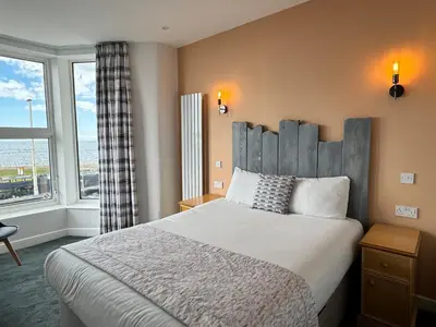 a bedroom with a large bed and a large window at Craig-y-Don in Blackpool