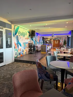 a restaurant with tables and chairs and a mural at Craig-y-Don in Blackpool