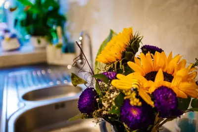a bouquet of flowers sitting next to a sink at Oh So Snug in Whalley