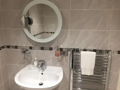a bathroom with a sink and a mirror at Oh So Snug in Whalley