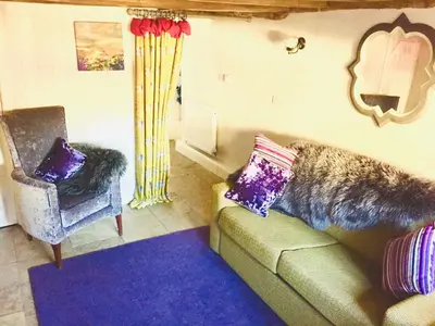 a living room with a couch and a chair at Oh So Snug in Whalley