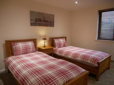 a bedroom with two twin beds and a window at 8 Swan House in Carnforth