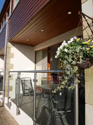 a balcony with a table and chairs and flowers at 8 Swan House in Carnforth