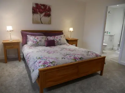 a bed in a bedroom with two tables and two lamps at 8 Swan House in Carnforth