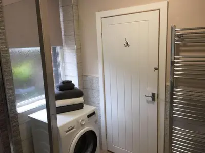 a laundry room with a washing machine and a door at Cosy Apartment in Private Courtyard in Preston