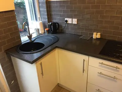 a kitchen with a sink and a counter top at Cosy Apartment in Private Courtyard in Preston