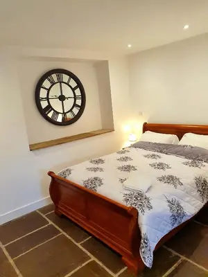 a bedroom with a bed with a clock on the wall at The Priory in Scorton
