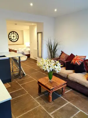 a living room with a couch and a table with flowers at The Priory in Scorton