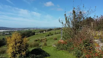 a view of a field with a fence and trees at Midsummer Barn in Darwen