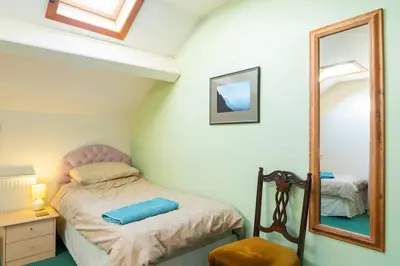 a small bedroom with a bed and a mirror at Midsummer Barn in Darwen