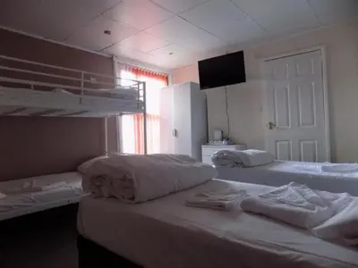 a bedroom with two bunk beds and a television at The Royal Windsor Hotel in Blackpool
