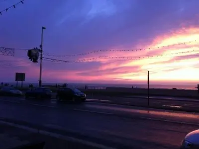 a sunset with cars parked on a road with a street light at The Royal Windsor Hotel in Blackpool