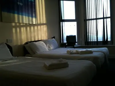 two beds in a hotel room with towels on them at The Royal Windsor Hotel in Blackpool