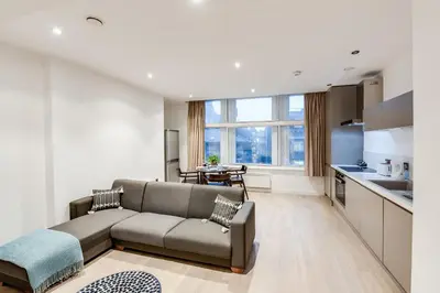 a living room with a couch and a kitchen at Terlon Apartments in Liverpool