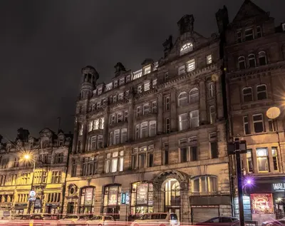 a large building is lit up at night at Terlon Apartments in Liverpool